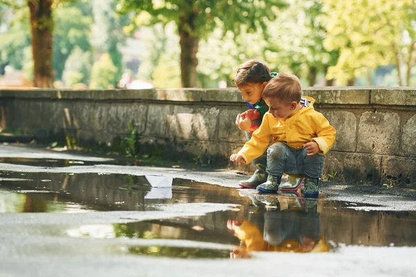 Birikintisinde Çocuklar Yağmurdan Sonra Parkta Eğleniyorlar — Stok fotoğraf