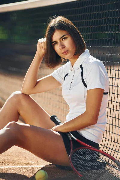 坐着拿着球拍 女网球选手白天在球场上 — 图库照片