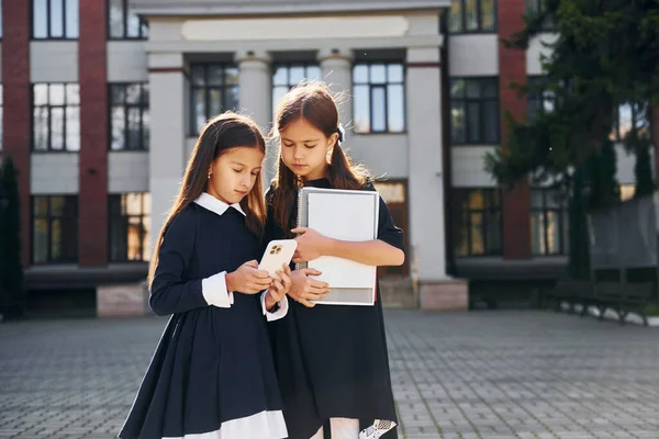 Bücher Halten Zwei Schülerinnen Stehen Gemeinsam Der Nähe Eines Schulgebäudes — Stockfoto