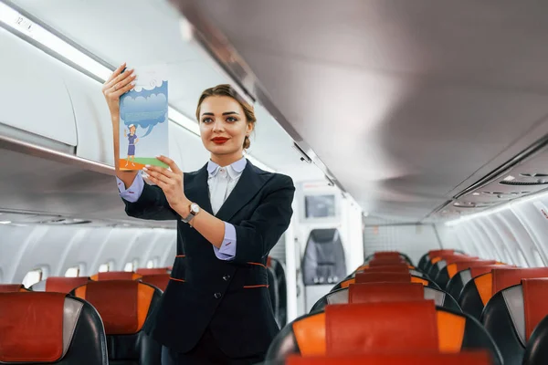 Κρατάει Χαρτί Οδηγίες Νεαρή Αεροσυνοδός Στη Δουλειά Αεροπλάνο — Φωτογραφία Αρχείου
