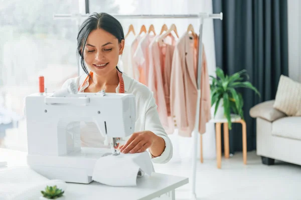 Professional equipment. Seamstress is in her office that is with different clothes.