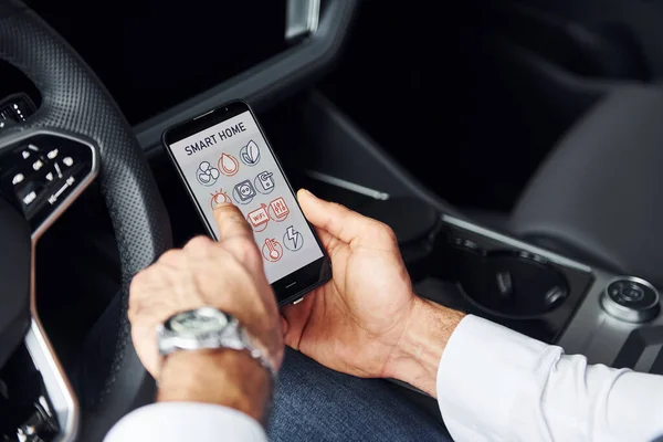Siedzi Samochodzie Zamknij Widok Rękę Człowieka Który Trzyma Telefon Etykietami — Zdjęcie stockowe