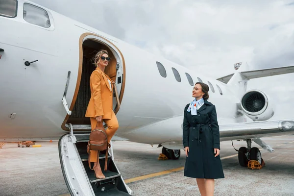 Ung Kvinde Gult Tøj Ledsages Flyselskab Arbejdere - Stock-foto