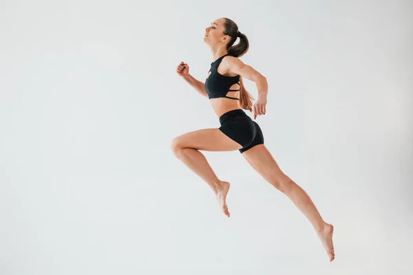 Fleksibilitas Tubuh Wanita Muda Berpakaian Sportif Melakukan Senam Dalam Ruangan — Stok Foto
