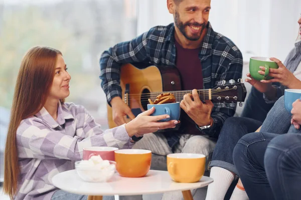 Hombre Toca Guitarra Acústica Grupo Amigos Tienen Fiesta Interior Juntos — Foto de Stock