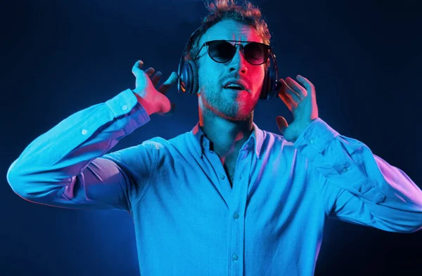 Hört Die Musik Neonbeleuchtung Junger Europäischer Mann Ist Dunklen Studio — Stockfoto
