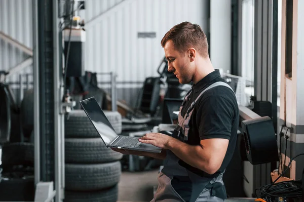 Sujetando Portátil Las Manos Hombre Uniforme Está Trabajando Servicio Automóviles —  Fotos de Stock