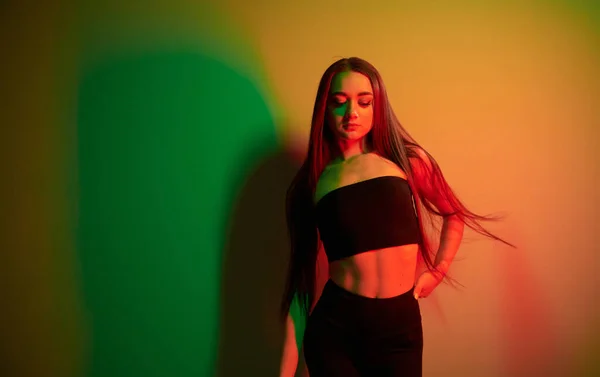 Duvara Yaslan Stüdyoda Neon Işığıyla Duran Şık Bir Genç Kadın — Stok fotoğraf