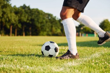 Güneşli bir gün. Genç futbolcu spor sahasında antrenman yapıyor..