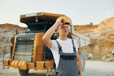 Aracın önünde. Gündüz vakti profesyonel üniformalı işçiler ödünç alma çukurundalar..