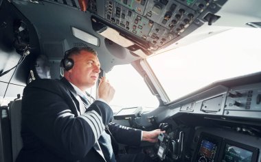 Yan görüş. Kokpitte profesyonel bir pilot var. İş kavramı.