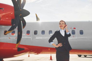 Uzaklara bakıyorum. Resmi siyah elbiseli genç hostes uçağın yanında dikiliyor..