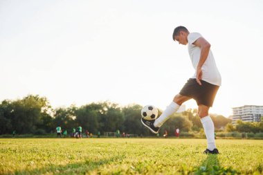 Farklı numaralar yapıyor. Genç futbolcu spor sahasında antrenman yapıyor..