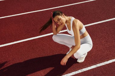 Oturup ara veriyoruz. Spor elbiseli genç bayan dışarıda egzersiz yapıyor..