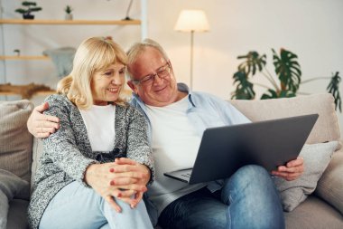 İnternet bağlantısı. Laptop kullanıyorum. Büyük adam ve kadın evde birlikteler..