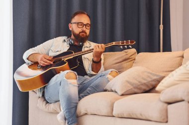 Rahatlamış hissediyorum. Gündelik giysiler içinde ve akustik gitarlı bir adam içeride..