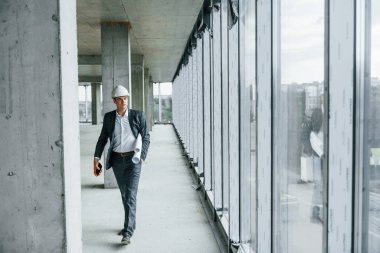 Binanın içindeki bir iş adamı. Resmi kıyafetli genç adam içeride inşaatta çalışıyor..