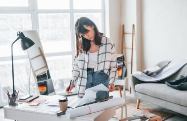 Masanın yanında duruyor. Genç bayan serbest çalışan gündüzleri evdedir..