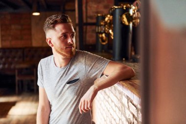 Gündüz vakti barda oturan sıradan elbiseli bir adam..