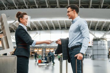 Belgeleri kontrol ediyorum. Resmi kıyafetli genç işadamı gündüz vakti havaalanında..