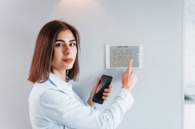 Kadın içeride akıllı ev teknolojisini kontrol ediyor..