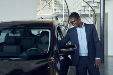 Arabaya bakıyorum. Siyah takım elbiseli genç Afro-Amerikan iş adamı Ototalon..