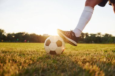 Manzarayı kapat. Genç futbolcu spor sahasında antrenman yapıyor..