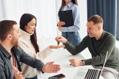 Ofiste dört kişi masa başında kapalı oturarak çalışıyor..