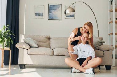 Telefonun ellerindeyken. Annesiyle birlikte gündüz vakti evde olan genç bir kız..