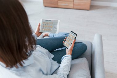 Evin içinde akıllı ev teknolojisini kontrol eden bir kadının arka görüntüsü..