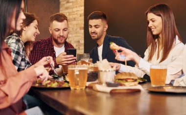 Hafta sonu tatili. Bir grup genç arkadaş barda birlikte oturup bira içiyorlar..