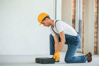 Dava beklemede. Gündüz vakti inşaatta üniformalı genç bir adam çalışıyor..