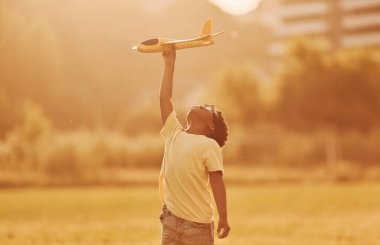 Hayal gücünün gücü. Pilot oyunu oynuyoruz. Afrikalı Amerikalı çocuk yaz günlerinde tarlada eğleniyor..