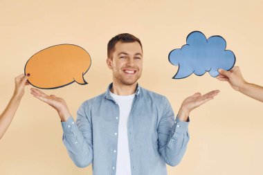 İki fikir arasında zor bir seçim. Stüdyoda duran adam mesaj için boş tabelalarla.