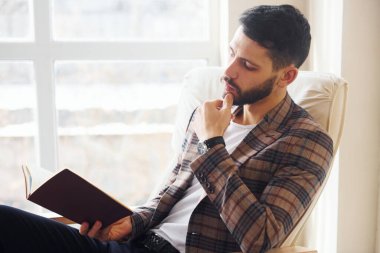 Kitap okuyor. Takım elbiseli genç bir iş adamı. Başarı kavramı.