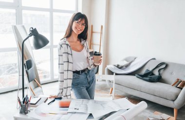 Masanın yanında duruyor. Genç bayan serbest çalışan gündüzleri evdedir..