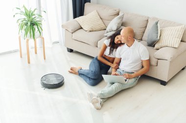 Kanepeye yaslanarak. Neşeli çift içeride birlikte..