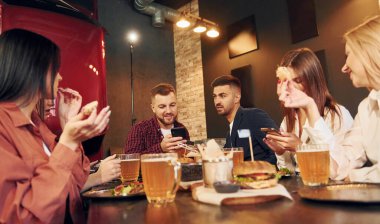 Hafta sonu harcamaları. Bir grup genç arkadaş barda birlikte oturup bira içiyorlar..