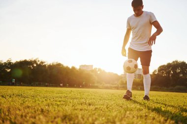 Farklı numaralar yapıyor. Genç futbolcu spor sahasında antrenman yapıyor..