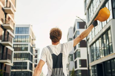 İş raporları. Gündüz vakti inşaatta üniformalı genç bir adam..