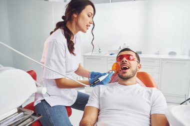 Klinikte dişçiye giden bir adam. Stomatoloji kavramı.