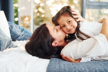 Yatağa uzanıyordu. Anne ve kızı evde birlikte vakit geçiriyorlar..