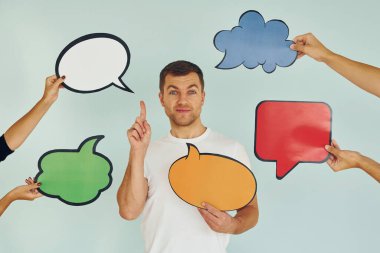 Birçok farklı düşünce. Stüdyoda duran adam mesaj için boş tabelalarla.