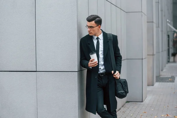 Bir bardak içkiyle. Siyah takım elbiseli ve kravatlı iş adamı şehir dışında..