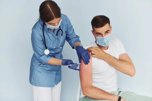 用注射器穿制服为病人注射疫苗的医生 — 图库照片