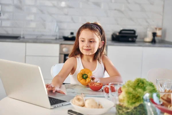 Happy Little Girl Sits Kitchen Food Laptop Table — Stock Photo, Image