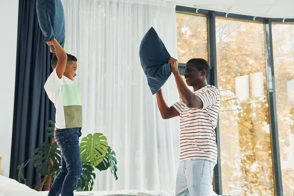 Yastık savaşı. Afrikalı Amerikalı baba ve küçük oğlu evde..