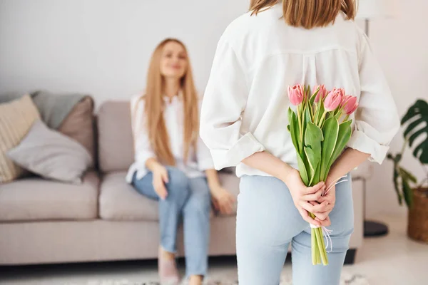 Håller Blommor Ung Mor Med Sin Dotter Hemma Dagtid — Stockfoto