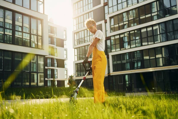 Yoğun bir gün. Bahçede çimleri çim biçen bir adam var..