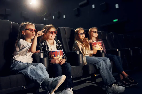 ポップコーンで 映画館に座って一緒に映画を見ている子供たちのグループ — ストック写真